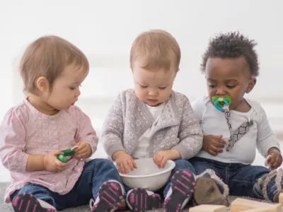 Drie baby's kijkend naar een kom
