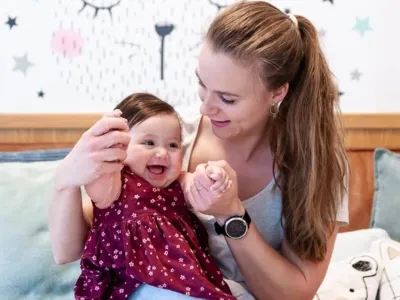 baby zit op schoot van een pedagogisch medewerker op het kinderdagverblijf van Impuls