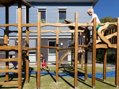 Jongens spelen buiten op een klimrek.