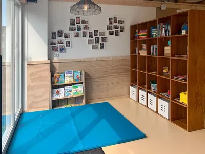 interieur van één van de groepen met speelmat en boekenkast