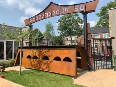 buitenspeelplaats met cortentstalen poort als ingang naar de blokkendoos