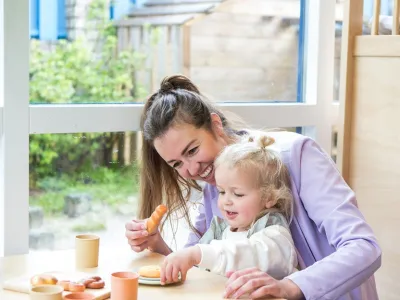 pedagogisch professional speelt met kind een theekransje