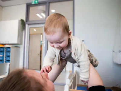 Baby wordt omhoog gehouden
