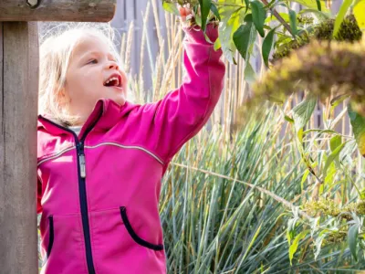 Kind kijkt naar de blaadjes van een plant