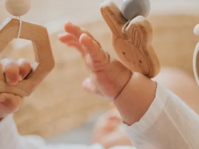 Baby playing with mobile made of wood