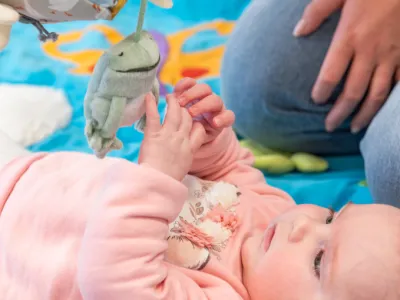 Baby-grijpend-naar-speelgoed