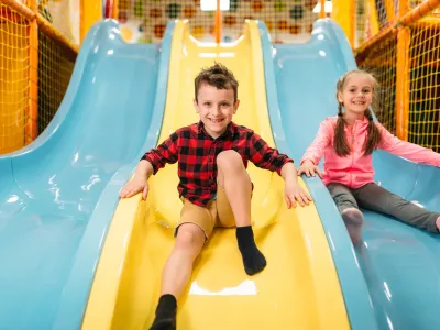 Kids riding from childrens slides in game center