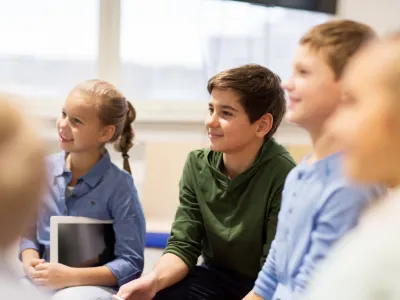 group of happy kids or friends learning at school