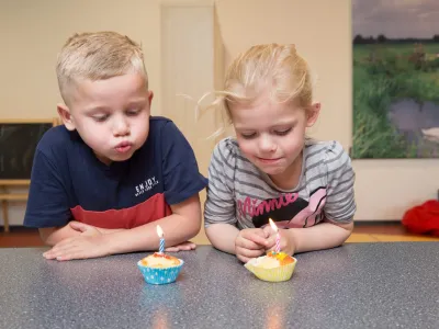 kinderen blazen kaarsjes uit