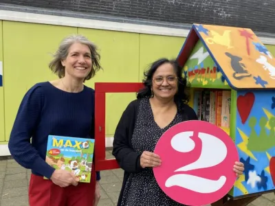 Taalles gratis met kinderopvang van 2Onder Elkaar. Asha pm staat naast taaldocente Nicole voor de locatie bij de minibieb