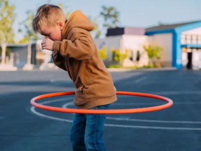 A caucasian boy is playing with a hula hoop on the 2022 11 15 09 45 06 utc