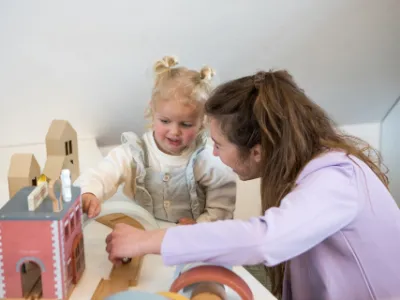 pedagogisch professional speelt met peuter