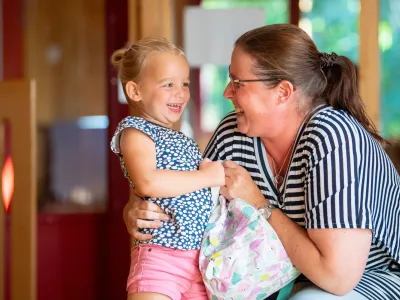 gro-up kind lacht met pedagogisch medewerker