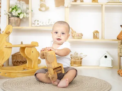 Jongetje op vloerkleed met houten speelgoed