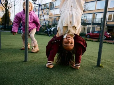 Meisje hangt ondersteboven op klimrek