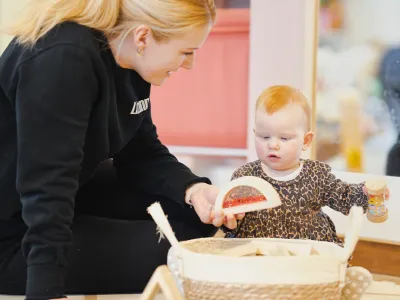 Pedagogisch medewerker van Kids Lodge speelt met baby