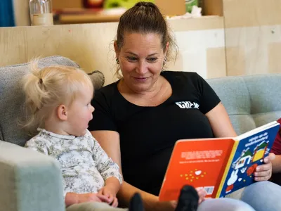 Pedagogisch medewerker van Kids Lodge leest voor aan peuter