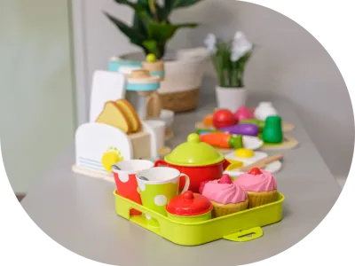 a table topped with a tray of cupcakes next to a potted plant