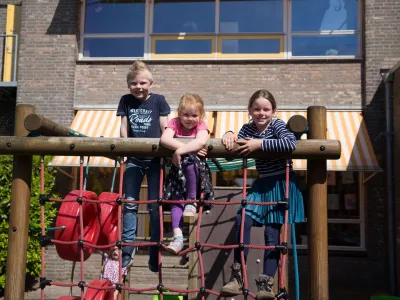 Kinderen klimmen op klimrek. De Oudercommissie adviseert over veiligheid op onze locaties.