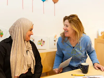 Twee pedagogisch professionals zitten aan tafel.