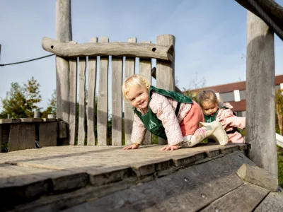 Peuters spelen buiten op het klimrek op de peuteropvang