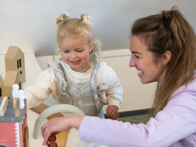 pedagogisch professional speelt met peuter
