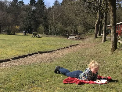 student ligt in het gras te lezen