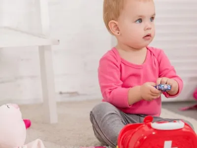 adorable child playing with first aid kit in children room