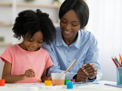 Creative african american little girl painting at daycare