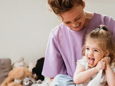 Pedagogisch Professional zit met kind op schoot op kinderopvang CompaNanny