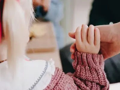 Pedagogisch Professional houdt hand kind vast op kinderopvang CompaNanny