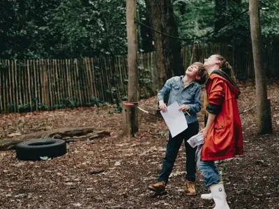 Kind en Pedagogisch Professional spelen in tuin kinderopvang CompaNanny