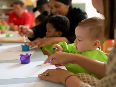 Ouders en kinderen verven samen bij de samenspeelgroep.