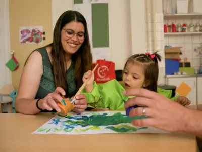 Moeder en peuter verven samen bij de samenspeelgroep.