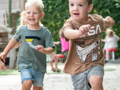 rennende jongetjes op een speelplein - De Spelende Kinderopvang Tilburg