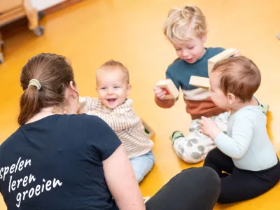 Blije kindjes spelen met pedagogisch professional van De Spelende Kinderopvang in Tilburg tijdens dagopvang