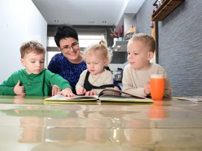 kinderen lezen een boek met een gastouder