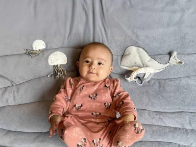 Baby ligt op speelkleed.