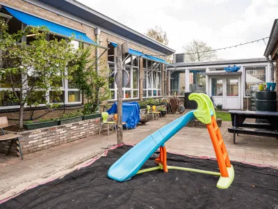De zandbak met glijbaan in de binnentuin