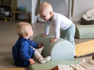 Twee kinderen op de dagopvang kijken lachend naar elkaar